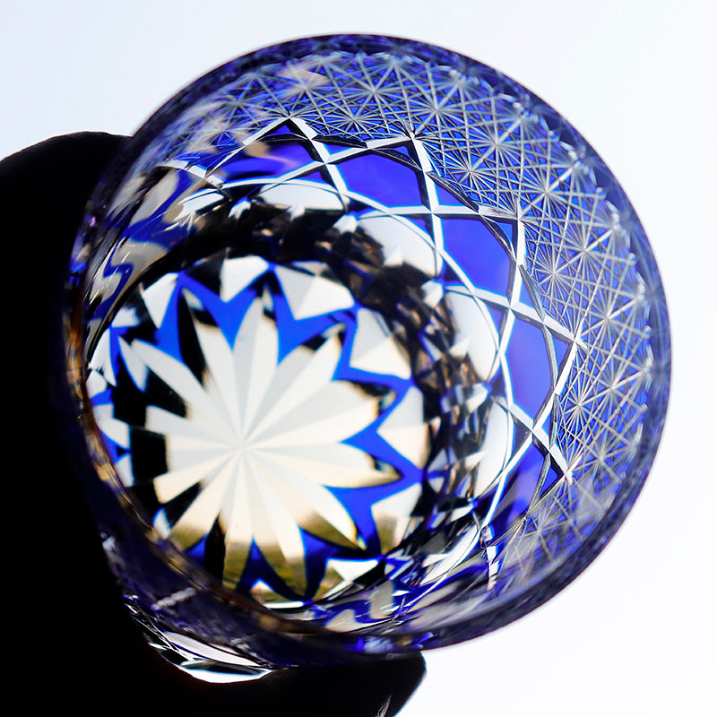 Hand cut crystal whiskey glass with blue and clear geometric starburst patterns