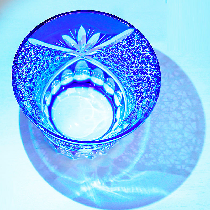 Hand cut crystal whiskey glass with intricate geometric patterns and blue lighting