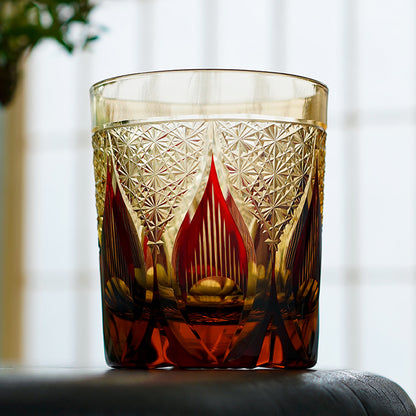 Hand cut crystal whiskey glass with intricate geometric pattern and amber liquid