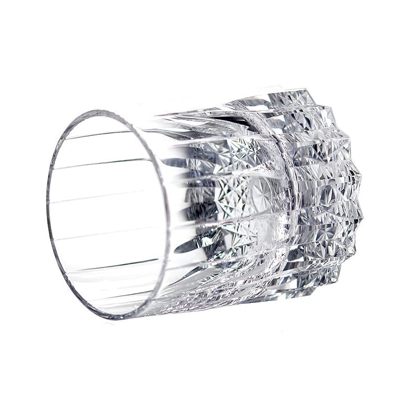 Side profile of transparent hand‑fluted glass tumbler, showcasing star‑faceted carved base structure